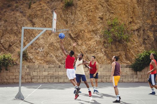 Basketball players playing basketball in the court outdoors
