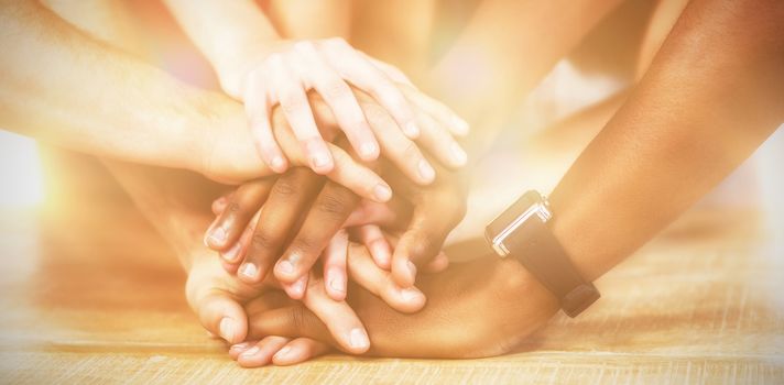 Business people putting their hands together on table at desk