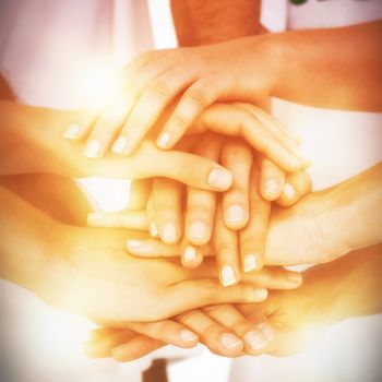 Mid section of volunteers putting hands together on white background