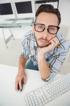 Nerdy bored businessman working on computer in his office