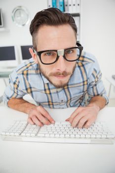 Nerdy businessman working on computer in his office