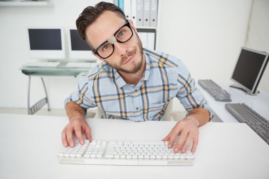 Nerdy businessman working on computer in his office