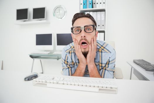 Nerdy businessman working on computer in his office
