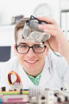 Smiling technician working on broken cpu in his office