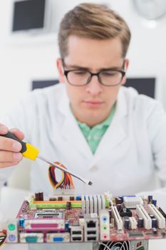 Technician working on broken cpu with screwdriver in his office