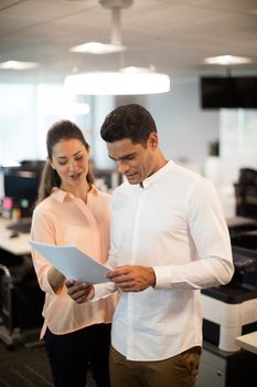 Business people discussing over documents in modern office