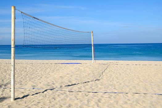 Closeup of Volleyball net on the tropical beach with blue sky. Sunny day on an empty beach.