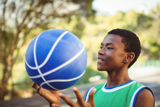 Close up of smiling young man playing with basketball outdoors