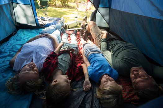 Smiling family lying in the tent