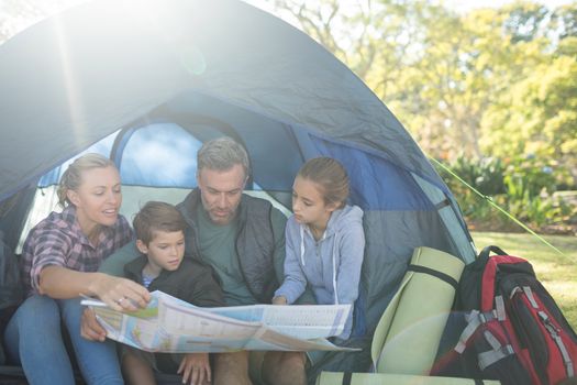 Family reading the map in tent on a sunny day