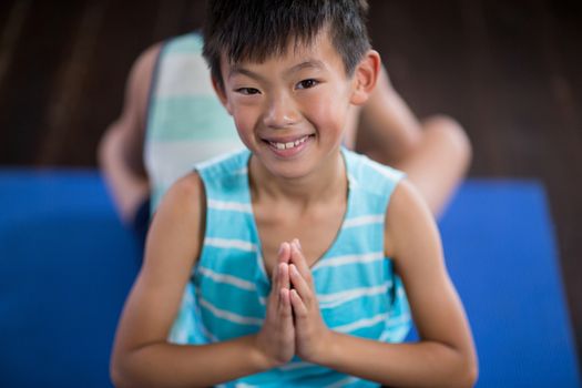 Close-up of smiling boy performing yoga at home