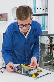 Young technician working on broken cpu in his office