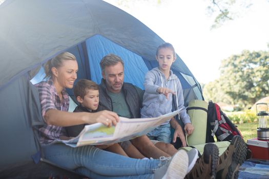 Family reading the map in tent at campsite