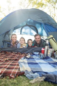 Portrait of smiling family lying in the tent