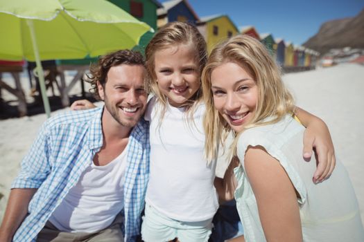 Portrait of smiling family at beach during sunny day