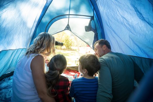 Rear view of family sitting in the tent