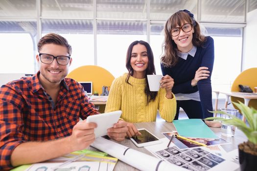 Portrait of business people at desk during meeting in office