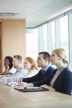 Business people sitting at conference table during meeting in board room