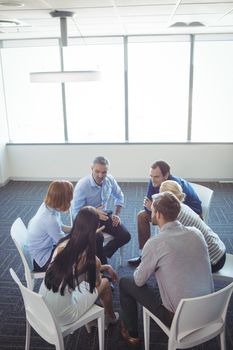 Creative business people interacting in circle at office