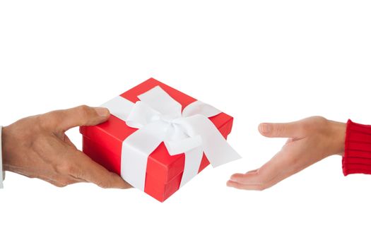 Couple passing a wrapped gift on white background