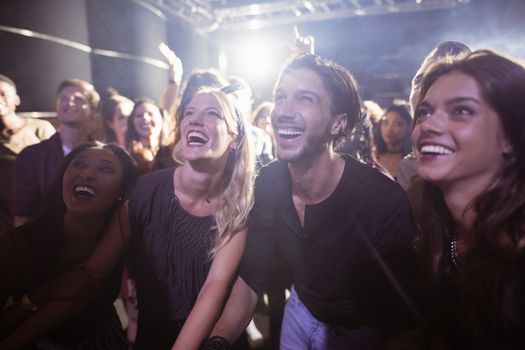 Cheerful people enjoying at nightclub during music festival