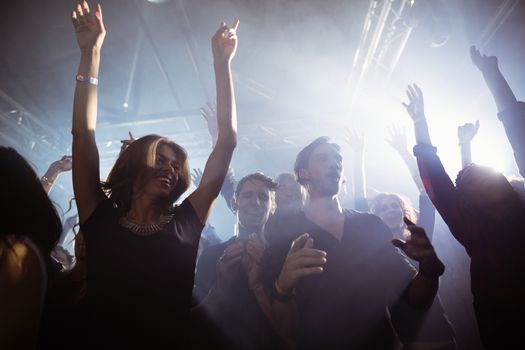 Low angle view of happy people dancing at nightclub