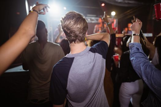 People enjoying music at concert in nightclub