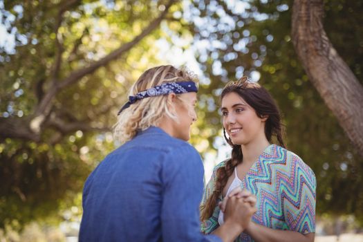 Close up of romantic couple holding hands against trees