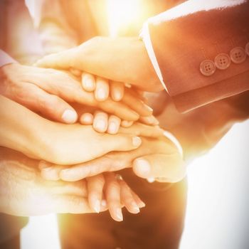 Business team stacking hands together in office