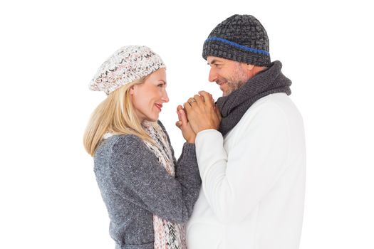 Couple in winter fashion embracing on white background