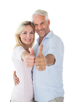 Smiling couple showing thumbs up together on white background