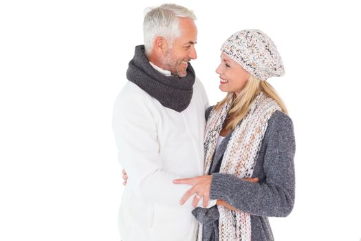 Happy couple in winter fashion embracing on white background