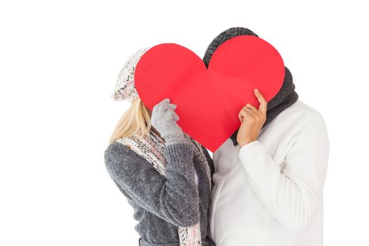 Couple in winter fashion posing with heart shape on white background