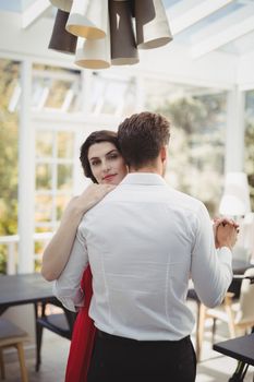 Romantic couple dancing with hand in hand in restaurant