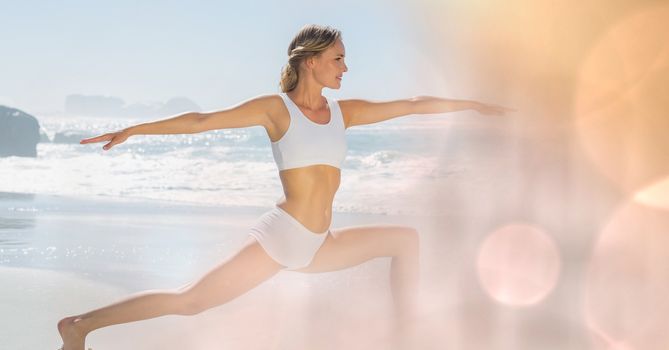 Digital composite of Fit young woman practicing yoga at beach