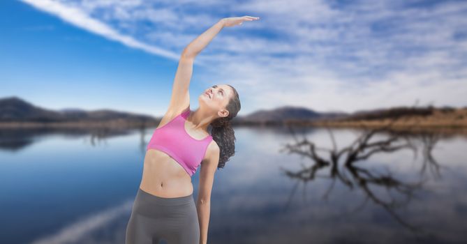 Digital composite of Double exposure of woman performing yoga at lakeshore