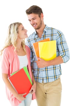 Attractive student couple smiling at each other on white background