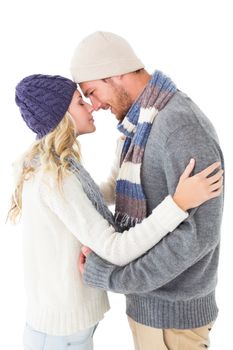 Attractive couple in winter fashion hugging on white background