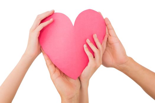 Couple holding a paper heart on white background