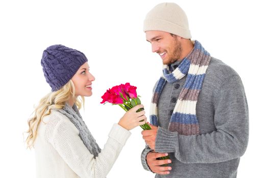 Attractive man in winter fashion offering roses to girlfriend on white background