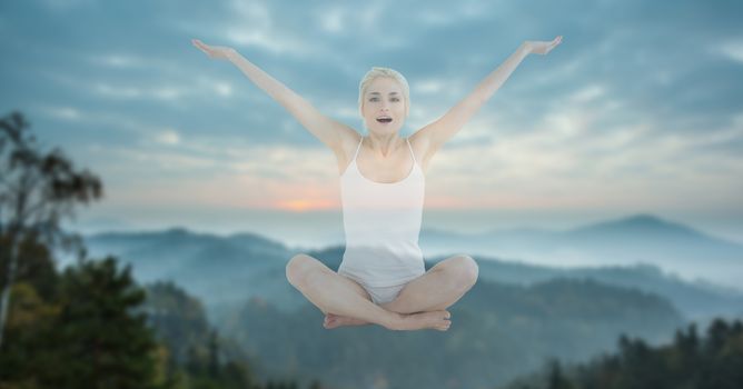 Digital composite of Double exposure of woman performing yoga in midair against mountains