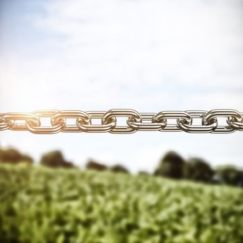 3d image of silver metal chain against countryside