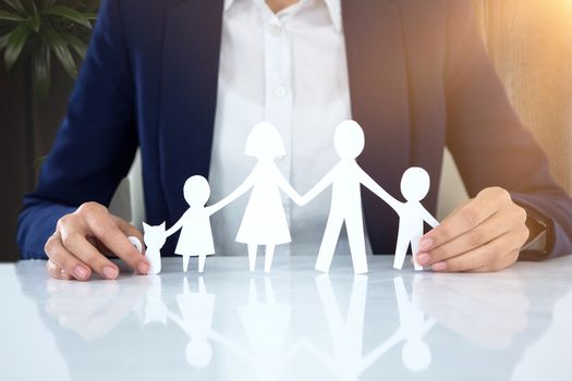 family in paper with a man in the background against wood