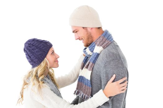 Attractive couple in winter fashion hugging on white background