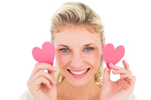 Attractive young blonde holding little hearts on white background