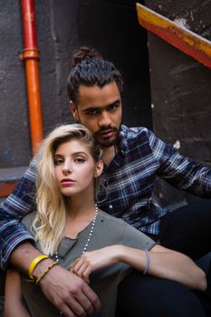 Portrait of romantic couple sitting on staircase of bar