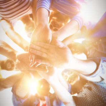 Creative business team stacking hands together in office