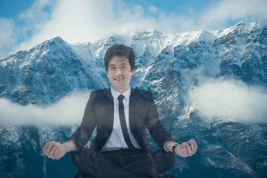 Digital composite of Businessman doing yoga position in front of snow-covered mountains