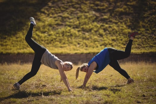 Portrait of beautiful women praising yoga during obstacle course in boot camp