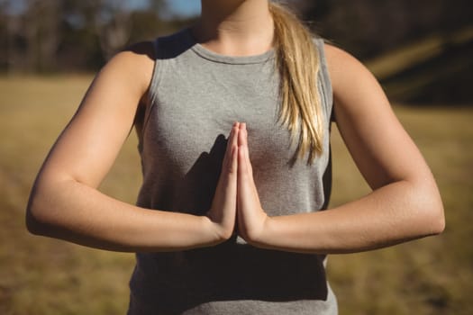 Mid section of woman praising yoga during obstacle course in boot camp